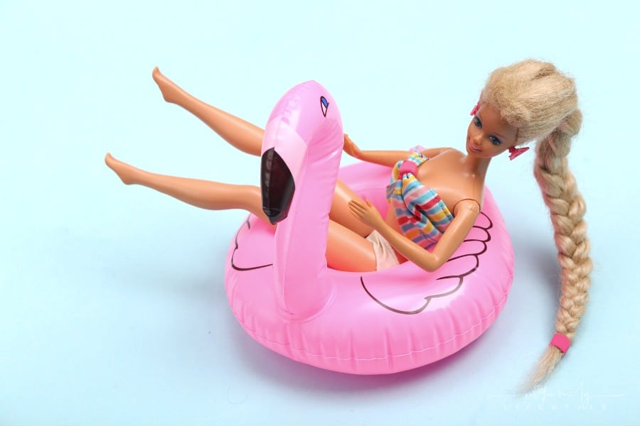 Barbie sitting in a flamingo pool float