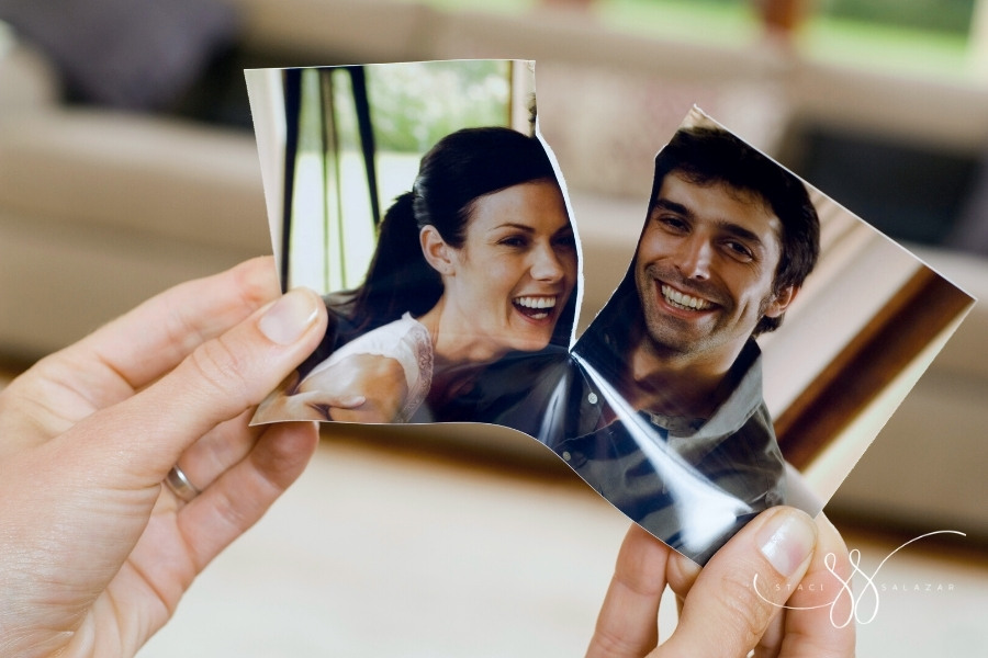 hands ripping photograph of a smiling couple
