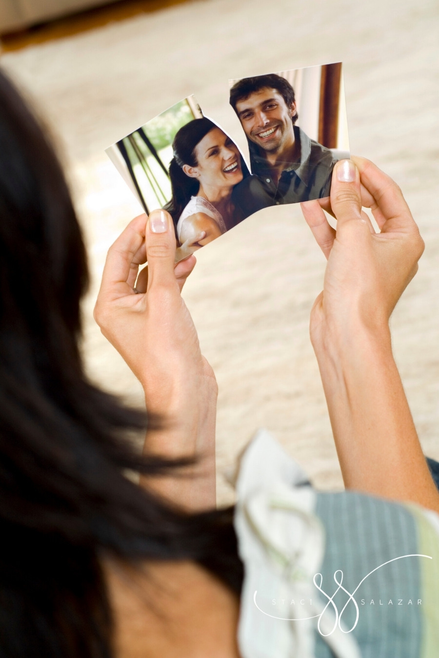 woman ripping a photograph of a smiling couple