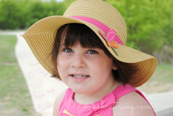 toddler smiling under straw sun hat