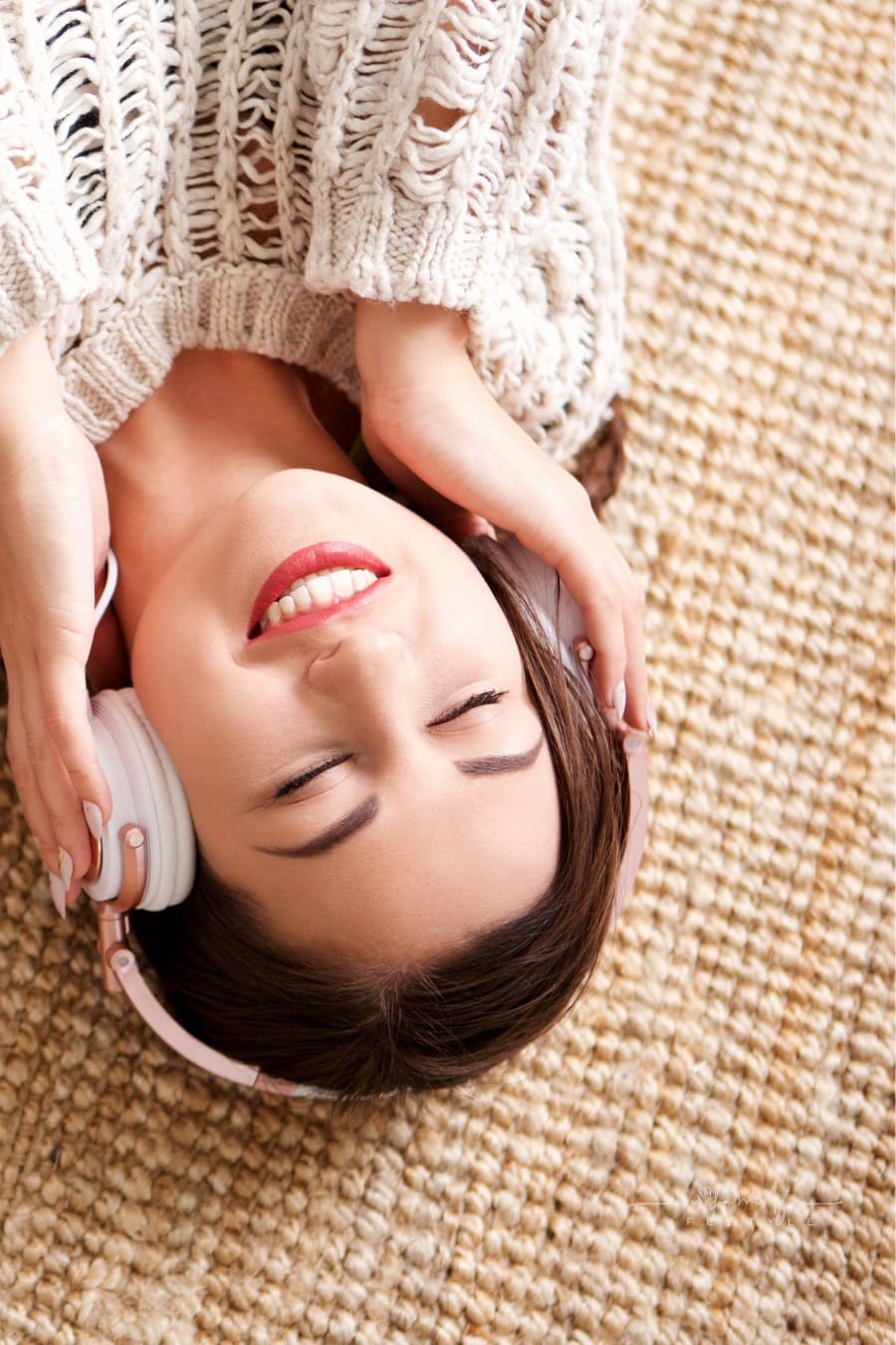 Woman Lying down smiling while listening to Headphones