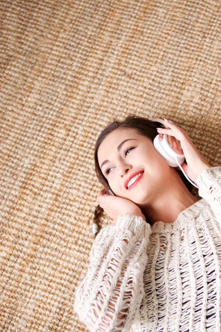 listening to audio books Woman Lying down smiling while listening to Headphones