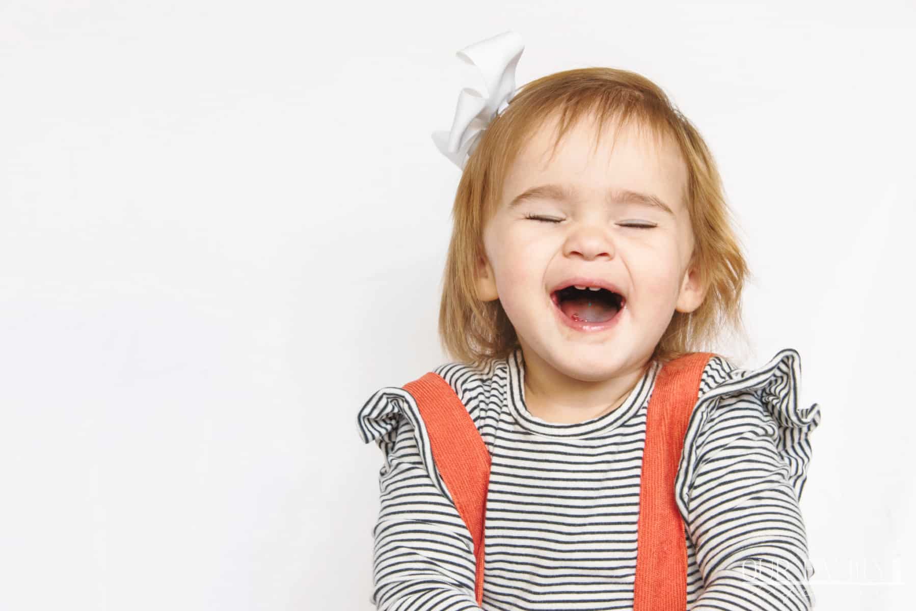 toddler granddaughter laughing with candy