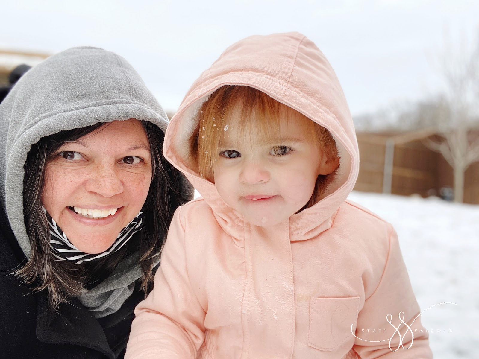 grandma and toddler posing in texas snow with hoodies