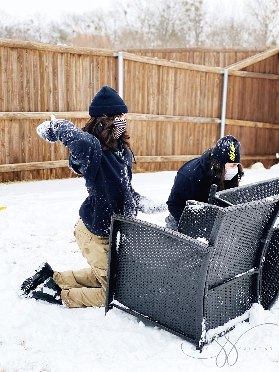 teens snowball fight behind patio furniture
